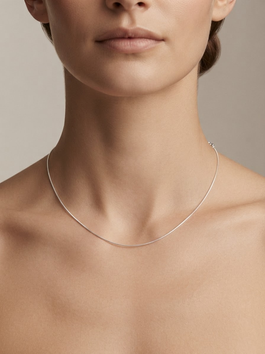 Cadena en plata fina sobre el cuello de una modelo